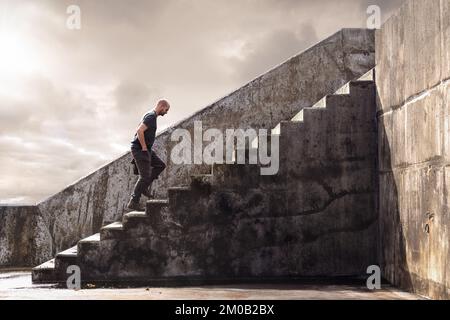 Man climbing concrete stairs Stock Photo