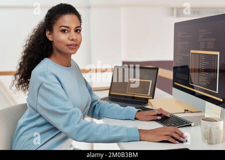 Portrait of female programmer working on computer in modern office of IT company Stock Photo
