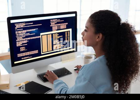 Serious female programmer writing code for testing computer software Stock Photo