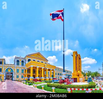 High flagpole with waving flag of Thailand and the main entrance to Ministry of Defence headquarters in Bangkok Stock Photo