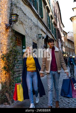Young multi-ethnic couple walking around town holding shopping bags Stock Photo