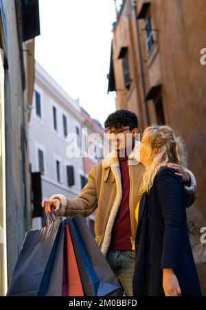 selective focus on blond woman of Young multi-ethnic couple doing Christmas shopping Stock Photo