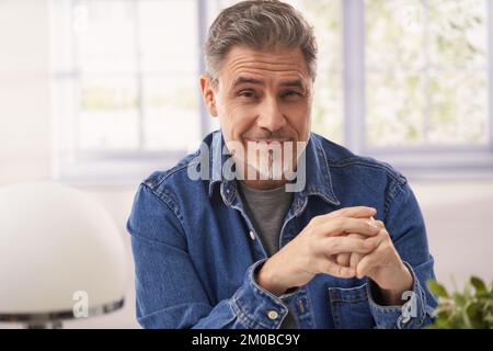 Portrait of of happy casual middle age casual man in office or at home, smiling. Stock Photo