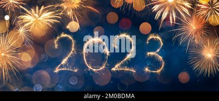 2023 New Year Celebration - Glitter On Golden Numbers With Sparkler And Fireworks In Black - Abstract Defocused Lights Stock Photo