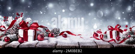 Gift On Snow In Winter White Background - Presents With Fir Branches And Red Ornaments Stock Photo