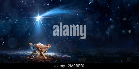 Nativity Scene - Birth Of Jesus Christ With Manger In Snowy Night And Starry Sky - Abstract Defocused Background Stock Photo