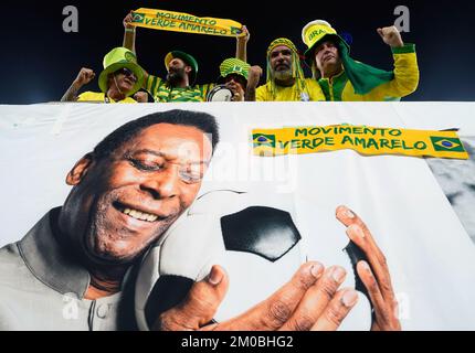 Brazil fans in the stands above a banner featuring former Brazil player Pele ahead of the FIFA World Cup Round of Sixteen match at Stadium 974 in Doha, Qatar. Picture date: Monday December 5, 2022. Stock Photo