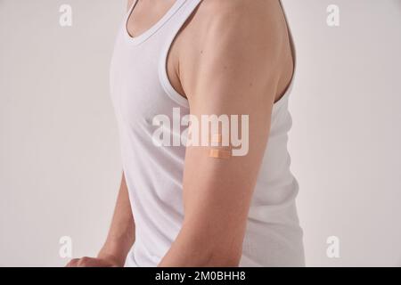 A scar from the Calmette-Guerin bacillus, BCG or anti-tuberculosis vaccine on the left arm of an unrecognizable man. Scar after injection. On a light background. High quality photo Stock Photo