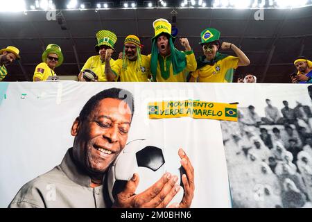 Brazil fans in the stands above a banner featuring former Brazil player Pele ahead of the FIFA World Cup Round of Sixteen match at Stadium 974 in Doha, Qatar. Picture date: Monday December 5, 2022. Stock Photo