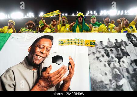 Brazil fans in the stands above a banner featuring former Brazil player Pele ahead of the FIFA World Cup Round of Sixteen match at Stadium 974 in Doha, Qatar. Picture date: Monday December 5, 2022. Stock Photo