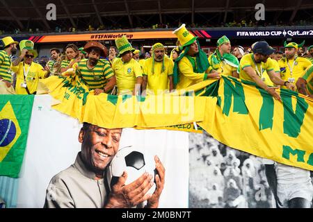 Brazil fans in the stands above a banner featuring former Brazil player Pele ahead of the FIFA World Cup Round of Sixteen match at Stadium 974 in Doha, Qatar. Picture date: Monday December 5, 2022. Stock Photo