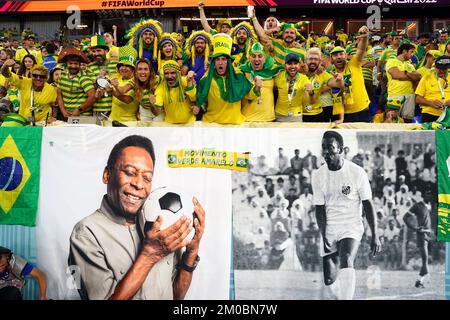 Brazil fans in the stands above a banner featuring former Brazil player Pele ahead of the FIFA World Cup Round of Sixteen match at Stadium 974 in Doha, Qatar. Picture date: Monday December 5, 2022. Stock Photo