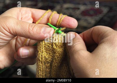 Woman hands knitting a beige pullover. Close-up of hands knitting. Stock Photo