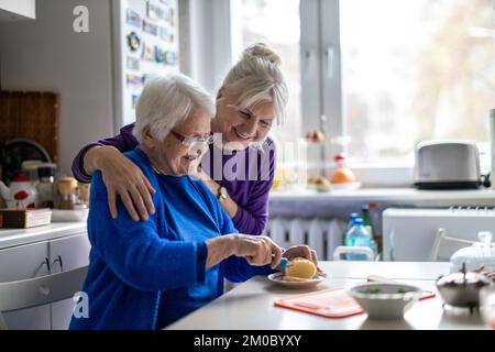 Woman spending time with her elderly mother at home Stock Photo