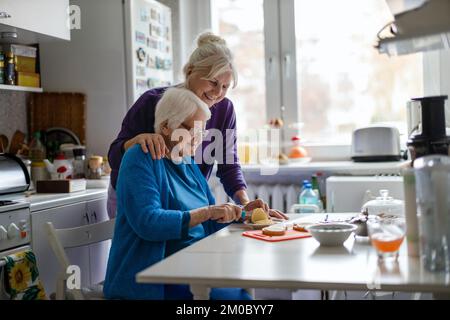 Woman spending time with her elderly mother at home Stock Photo