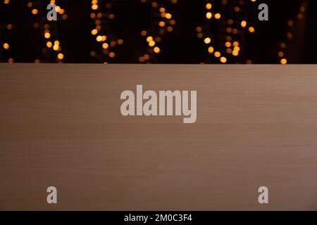 photo edge of the world wooden table in the background festive illumination blurred in bokeh Stock Photo