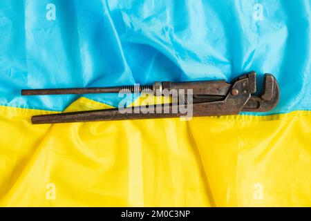 Old rusty gas key lies on the flags of Ukraine close-up Stock Photo