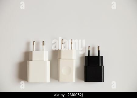 Charging blocks for the phone lie on a white background close-up, three power supplies Stock Photo