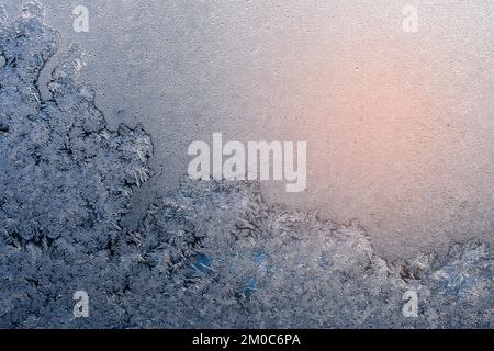 Frozen surface with icy pattern on window glass in cold winter day Stock Photo