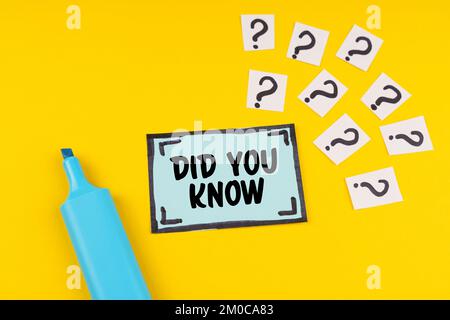 Education concept. On the yellow surface lies a blue marker, question marks and a sticker with the inscription - DID YOU KNOW Stock Photo