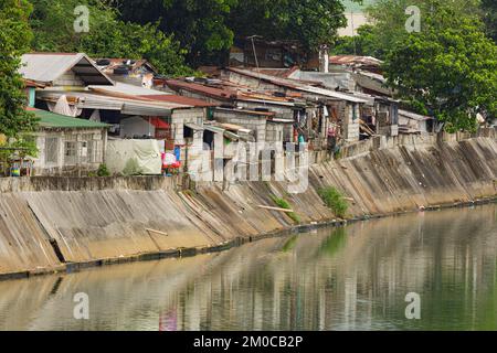 Poor people living in poverty along the canals of Manila Philippines with copy space Stock Photo