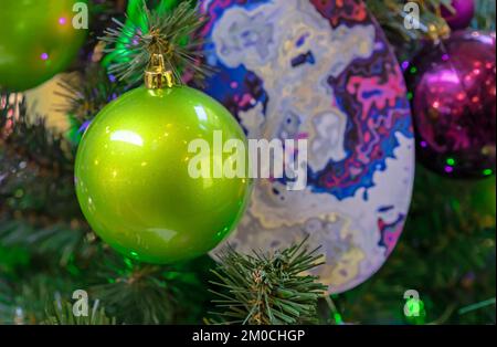 Green frosted Christmas ball on a Christmas tree close-up. Stock Photo