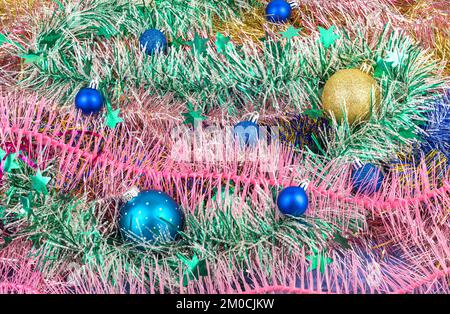 Tinsel of different colors and Christmas balls. New Year's tinsel. Abstract background or texture. Stock Photo