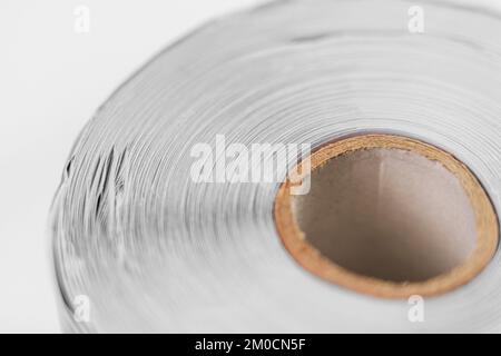 Rolled up paper roll on white background. Rotating recycled cellulose. Macro. Rotation Stock Photo