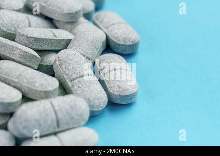 Tryptophan sedative pills on a colored blue background. Medical remedy for depression and insomnia. Natural pharmaceutical antidepressant Stock Photo