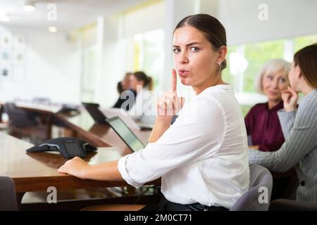 Young white brunette businesswoman saying shh Stock Photo