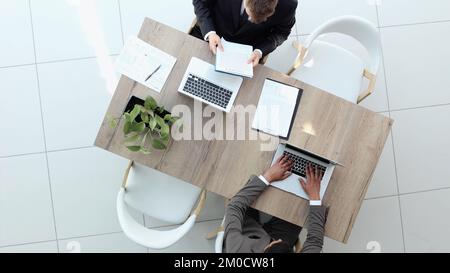 Two successful smiling businessmen are working on a laptop. view from above Stock Photo