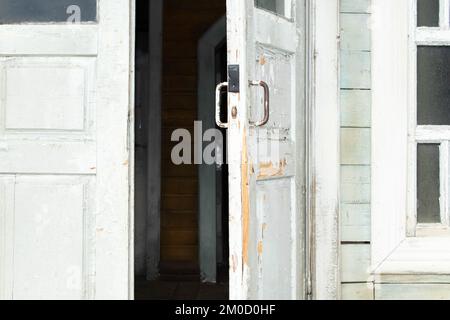 Grey retro style wooden door on gery cement wall background Stock Photo