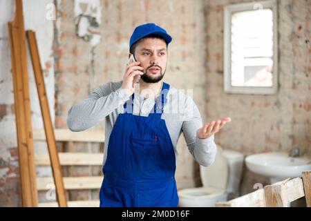 Builder talking on phone at construction site Stock Photo