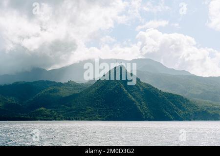 View of tree covered hills and mountains in Caribbeans. Rainforest land along waters of Atlantic Ocean Stock Photo