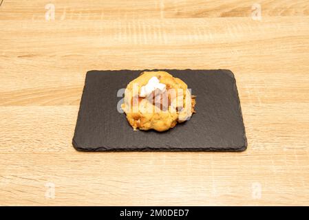 Big delicious chocolate chip cookie dessert with marshmallows on black slate on wooden table Stock Photo