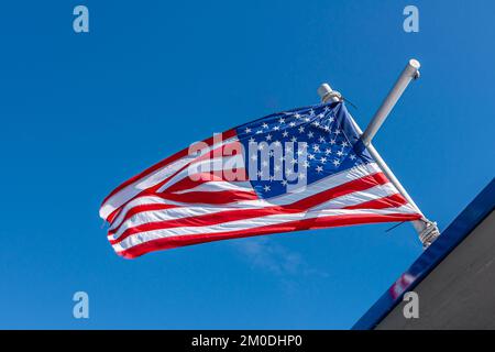 Seward, Alaska, USA - July 22, 2011: Closeup of open flowing USA National flag, stars and stripes, against blue sky Stock Photo