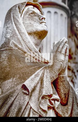 Faithfull Virgin Mary with praying hands and blessing, looking at the sky Stock Photo