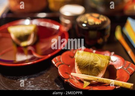 Mochi covered with leaf served on traditional Japanese dish Stock Photo