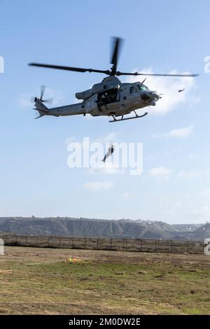 U.S. Marines with Marine Light Attack Helicopter Squadron 169, Marine Aircraft Group 39, 3rd Marine Aircraft Wing (MAW), lift U.S. Navy Master Chief Petty Officer Ryan Grant, a departmental leading chief petty officer with Helicopter Sea Squadron 3, during exercise Steel Knight 23, at Imperial Beach, California, Nov. 29, 2022. The exercise provides 3rd MAW an opportunity to refine Wing-level warfighting in support of I Marine Expeditionary Force and fleet maneuver. (U.S. Marine Corps photo by Lance Cpl. Isaac Velasco) Stock Photo