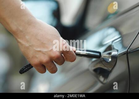 A man opens a car door with a key, close-up hand. Dead battery in remote key Stock Photo