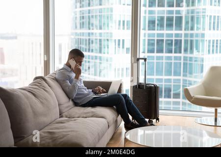 Busy young millennial travelling business man using digital gadgets Stock Photo