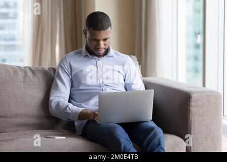 Busy focused Black freelance business man typing on laptop Stock Photo