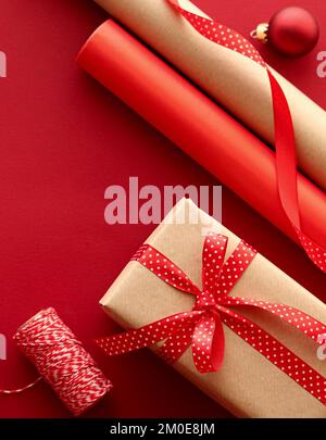 Christmas preparation, boxing day and holidays gift giving, xmas craft paper and ribbons for gifts boxes on red background as wrapping tools and decorations, diy presents as holiday flat lay design Stock Photo