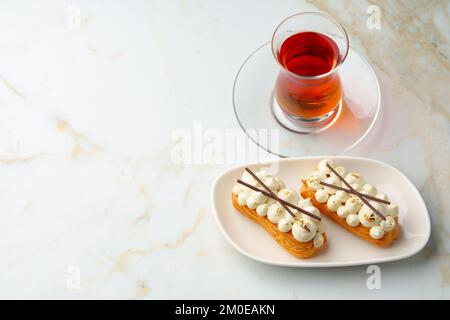 Two eclairs with white custard on whhite plate Stock Photo