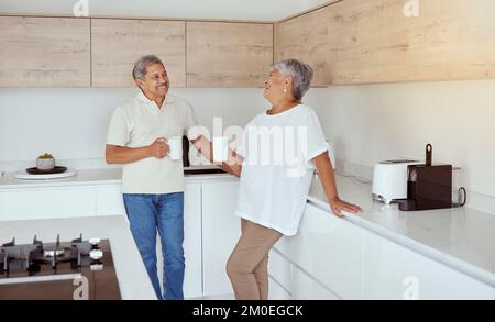 Mixed race senior couple enjoying coffee in the morning at home. Smiling elderly husband and wife standing together and drinking tea in kitchen. Happy Stock Photo