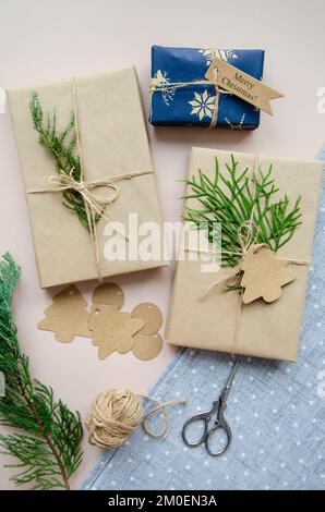 Hand crafted gifts on dark background with Christmas decorations. Seasonal background shot from above. Flat lay, top view. Tag mockup, copy space on t Stock Photo