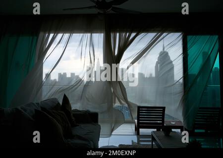 The Wind Rustles The wind rustles the curtain of the panoramic window with a cityscape ...