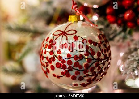 Gold and red large Christmas decoration bauble hanging on a Christmas tree. Stock Photo