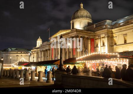 LONDON, UK - 6TH DEC 2022: Trafalgar Square in London at Christmas. Showing market stalls and people. Stock Photo