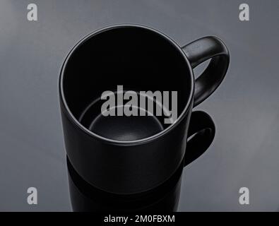 Black mug on black background, top view Stock Photo